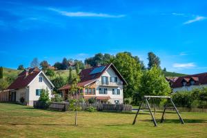 a yard with a swing set in front of a house at Ferienhaus am Brunnen in Eibiswald