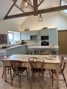 a kitchen with a large wooden table and chairs at High Shilford Barn in Ridingmill