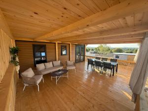 a wooden porch with a couch and tables on a deck at The Nest in Drage +15 photos