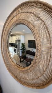a round rattan mirror on a wall in a living room at The Urban Elm Guesthouse in Antwerp +30 photos