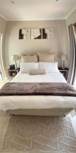 a large white bed in a bedroom with two lamps at The Urban Elm Guesthouse in Antwerp