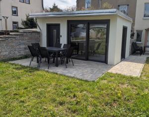 a patio with a black table and chairs on it at Wasserschloss Apt - von Taube Refugium für 1-2 Personen mit Terasse, Küche, Garten, Wifi, TV, Bar, Dusche, Waschmaschine, Parkplatz, versteckt gelegen in Neukirchen