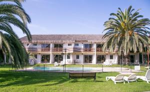 a large building with a pool and palm trees at Cabañas Las Añañucas I in La Serena