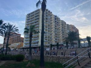 a tall building with palm trees in front of it at Estudio Benalmádena Costa in Benalmadena Costa
