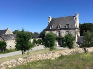 カンカルにあるLe Nid d'Emeraudeの目の前に木々が植えられた古い石造りの家