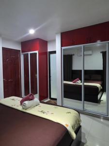 a bedroom with two beds and red cabinets at Samayra's Apartment in Nadi