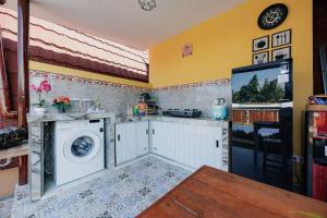 a kitchen with a washing machine and a tv at The Lavana De'Bale Marcapada in Saba