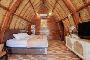 a bedroom with a bed and a tv in a room at The Lavana De'Bale Marcapada in Saba
