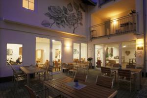 a restaurant with wooden tables and chairs in front of a building at Romantik Hotel Landhaus Biewald in Göttingen