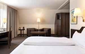 a hotel room with a bed and a desk at elaya hotel noerdlingen, Trademark by Wyndham in Nördlingen +65 photos