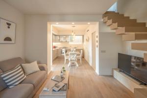 un salon avec un canapé et un escalier dans l'établissement Luxury Duplex - Heart of Corciano - ItalyWeGo, à Corciano