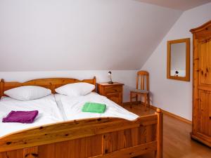 a bedroom with a wooden bed with white sheets at Holiday Home Richtpfad by Interhome in Norden