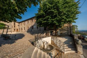 un escalier menant à un bâtiment avec un arbre dans l'établissement Luxury Duplex - Heart of Corciano - ItalyWeGo, à Corciano