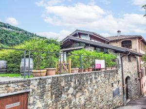 a building with potted plants on a stone wall at Apartment Cantagallo by Interhome in Vernate