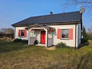 a small white house with red shutters and a red door at Holiday Home Butterfly Lux by Interhome in Dobra