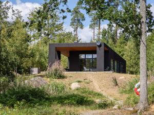 a black house on a hill with trees at Holiday Home Paradiset by Interhome in Holmsjö