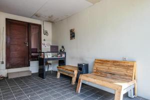 a room with a wooden bench and a desk at David Houses Nusa Dua Beach Bali RedPartner in Nusa Dua