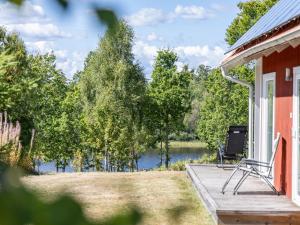 a house with a deck with a view of a river at Holiday Home Skogstorp by Interhome in Holmsjö