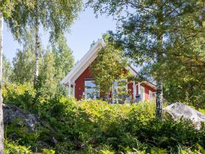 a red house surrounded by trees and bushes at Holiday Home Skogstorp by Interhome in Holmsjö