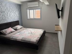 Ένα ή περισσότερα κρεβάτια σε δωμάτιο στο דירת אירוח שקטה וקומפקטית