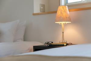 a lamp sitting on a table next to a bed at インザ富士 in Fujiyoshida