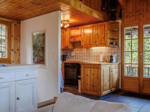 a kitchen with wooden cabinets and a stove at Chalet Chalet Soleil by Interhome in Nendaz