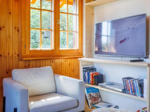 a living room with a chair and a television at Chalet Chalet Soleil by Interhome in Nendaz +35 photos