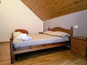 a bedroom with a bed and a wooden ceiling at In da Nou in Paularo