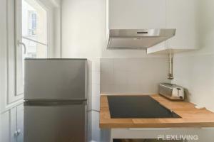 eine Küche mit einem Kühlschrank aus Edelstahl und einer Spüle in der Unterkunft Cozy Room in Alésia Paris 14th in Paris