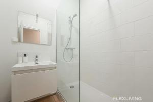 ein weißes Badezimmer mit Dusche und Waschbecken in der Unterkunft Cozy Room in Alésia Paris 14th in Paris