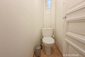 ein kleines Bad mit WC und Tür in der Unterkunft Cozy Room in Alésia Paris 14th in Paris