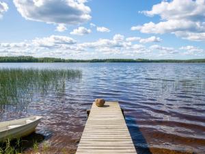 ein Teddybär sitzt auf einem Steg an einem See in der Unterkunft Holiday Home Männikkö by Interhome in Kammola