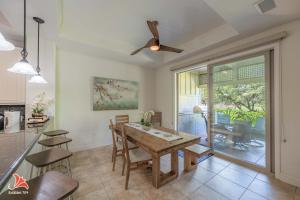 a kitchen and dining room with a table and a ceiling fan at 2BR bright quiet condo in Kulalani sleeps 6 in Waikoloa