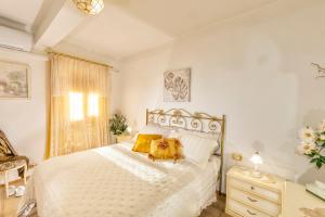 a bedroom with a large white bed with yellow pillows at Villa Viola in Chianciano Terme