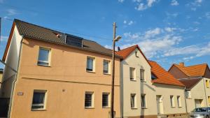 a building with orange roofs and a street light at Ferienwohnung Blumenberg Hahn Grabenstraße in Staßfurt