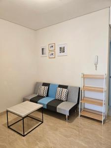 a living room with a couch and a table at Premium Apartment Podomoro 1 Bedroom with Best Garden & City View in Medan