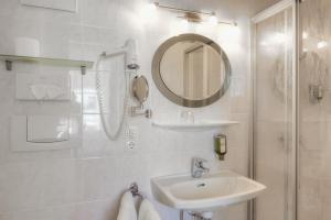 a white bathroom with a sink and a mirror at Hametner mit Innviertlerhaus mit Thermenzugang in Bad Hall +96 photos