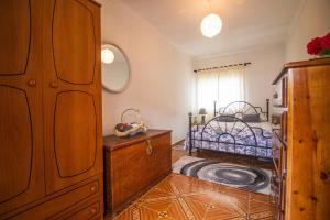 a bedroom with a bed and a wooden dresser at Quinta Ti Lita in Tocha