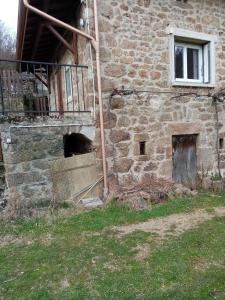 a stone building with a staircase and a window at Les claux -185 rue des Claux in Saint-Romain-dʼAy