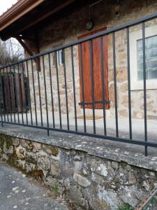 a fence in front of a stone building at Les claux -185 rue des Claux in Saint-Romain-dʼAy