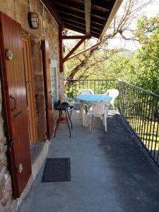 a patio with a table and chairs on a balcony at Les claux -185 rue des Claux in Saint-Romain-dʼAy