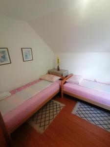 パレにあるSweet Houseのピンクのシーツが敷かれた部屋にベッドが2つ