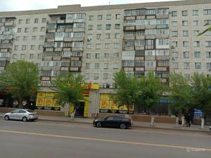 a large building with cars parked in front of it at Абдирова 19 в центре in Karagandy