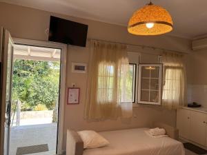 a bedroom with a bed and a window and a chandelier at Sykia Itamos Studio-2 in Sykia Chalkidikis