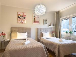 a bedroom with two beds and a chandelier at Prinshöjden Apartments & Villas - Katrineholm Residential in Katrineholm