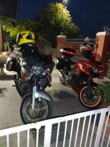 two motorcycles are parked next to a fence at B&B Villa Firefly in Modena
