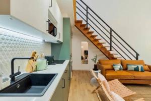 cocina con fregadero y sala de estar con sofá en GuestReady - Casa Karolina, en Setúbal