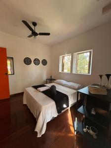 a bedroom with a bed and a ceiling fan at Hari Eco Pousada in Brumadinho