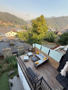 einen Balkon mit einem Sofa und Stühlen auf einer Terrasse in der Unterkunft Tu&Mi Villafranca in Villafranca del Bierzo