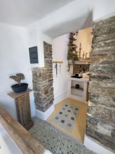 a room with a stone wall and a kitchen at Manolia House in Parikia
